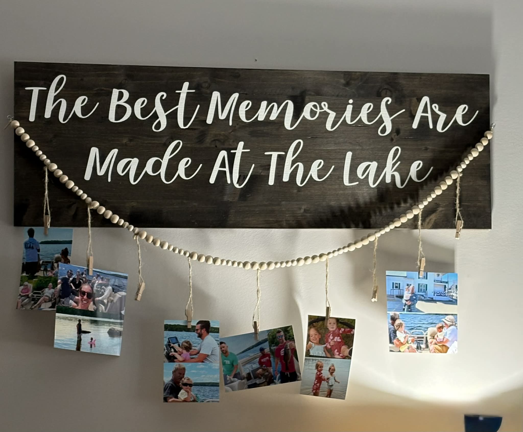 The Best Memories Are Made At The Lake sign with bead garland and hanging photos