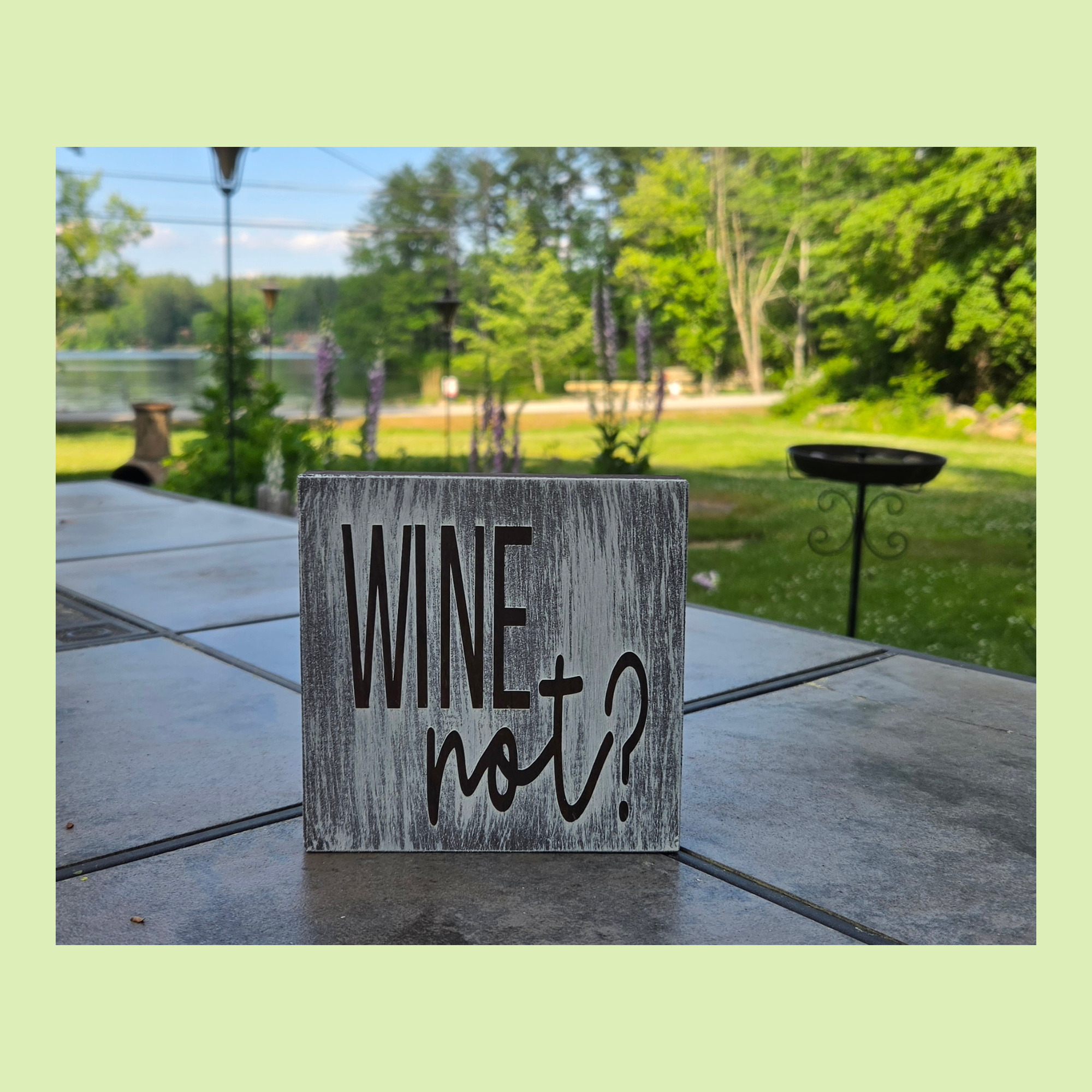 Wine Not sign on gray distressed pine by the lake
